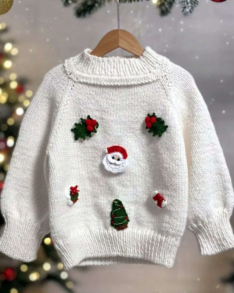 Weisser Kinderpullover mit gestickten Weihnachtsmotiven